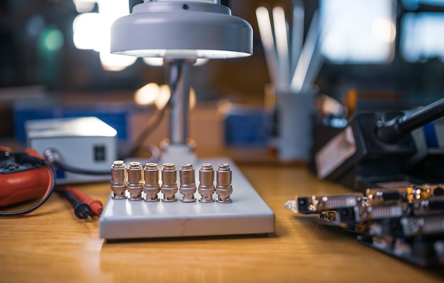 Modern microscope, connectors component and large green microcircuit in workshop laboratory