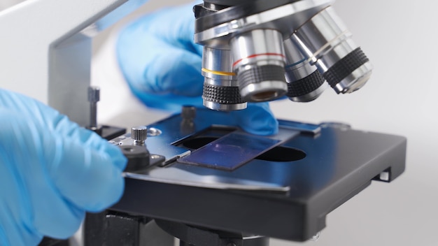 A modern microscope in a sterile, bright laboratory room analyzing cell samples.