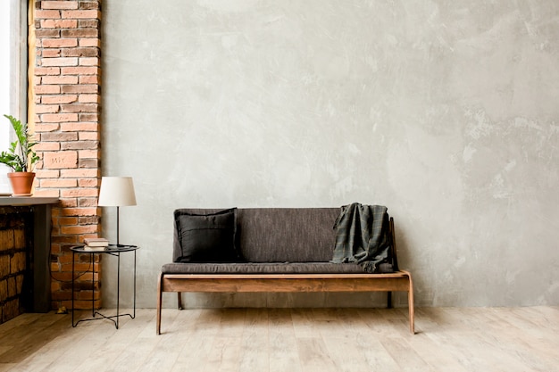 Modern minimalist interior with a sofa on an empty wall in the living room, mock up wall in living room room, loft style