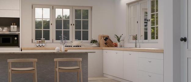 A modern minimalist white kitchen interior with a kitchen island, wooden chairs, a minimal white kitchen counter, sink, modern kitchen appliances, and decor. 3d render, 3d illustration