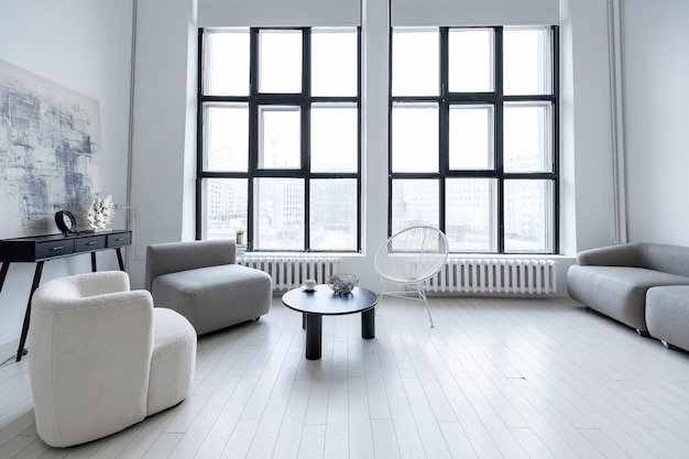 Modern minimalistic interior design of light bright monochrome room with black and white furniture clean white walls and huge windows