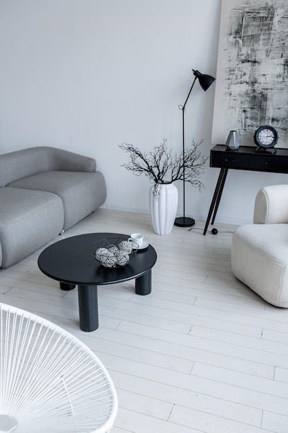 Современный минималистичный дизайн интерьера светлой яркой монохромной комнаты с черно-белой мебелью, чистыми белыми стенами и огромными окнами