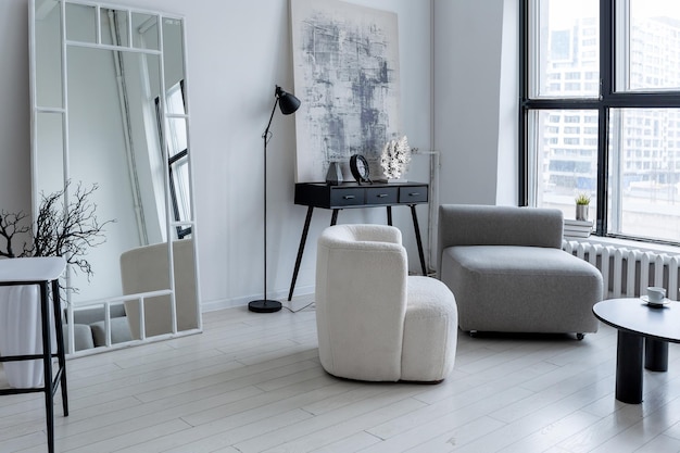 Modern minimalistisch interieur van lichte, heldere monochrome kamer met zwart-wit meubilair, schone witte muren en grote ramen