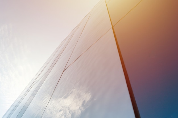 Modern mirror wall decoration of business center, copy space. Bottom view to texture of exterior design. Contemporary pattern of buildings. Looking up.