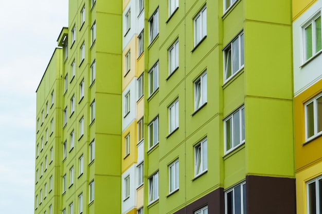 Фото Современный многоэтажный дом в новом жилом комплексе на фоне голубого неба концепция ипотечного жилищного кредитования и счастливой семейной жизни красивый разноцветный дом в городе
