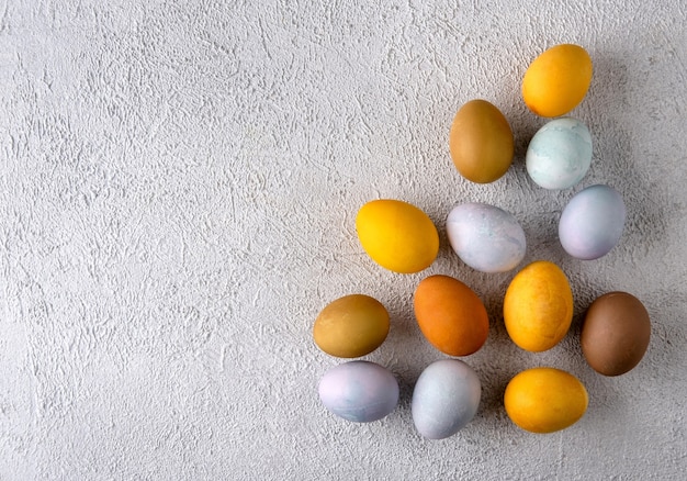 Modern natural dyed easter eggs. Easter composition on grey concrete background.