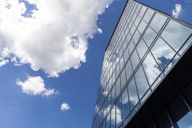 Modern office building with glass facade on a clear sky background Transparent glass wall of office building