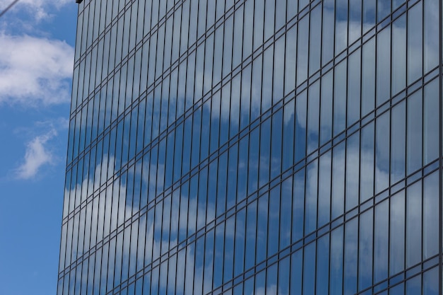 Современное офисное здание со стеклянным фасадом на фоне ясного неба Прозрачная стеклянная стена офисного здания