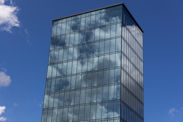 Modern office building with glass facade on a clear sky background Transparent glass wall of office building