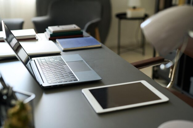 ラップトップとタブレットを備えた近代的なオフィスデスク