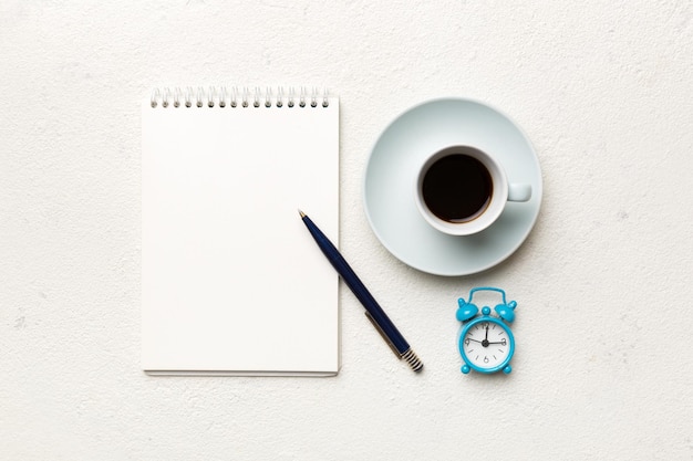 写真 ノートブックとコーヒーのカップと他の物資を備えたモダンなオフィスデスクテーブルあなたのための空白のノートブックページデザイントップビューフラットレイ