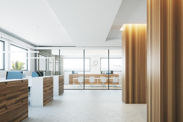 Modern office interior with a concrete floor, wooden columns and computer tables. A conference room in the background. 3d rendering mock up