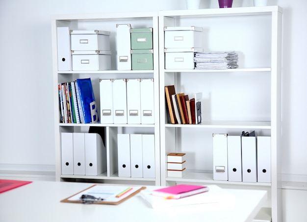 Modern office interior with tables, chairs and bookcases