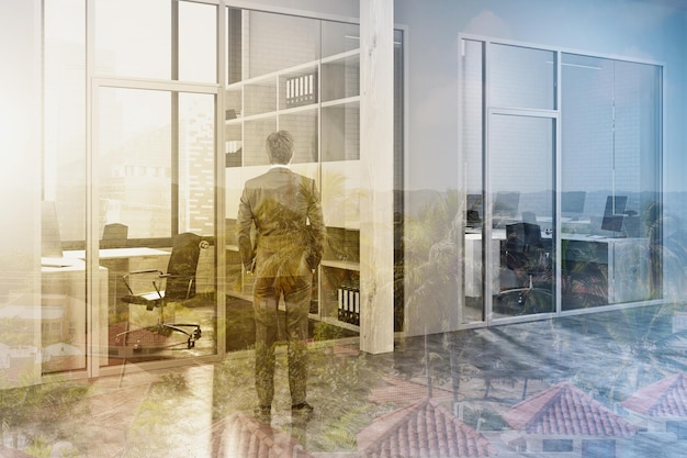 Modern office lobby with gray and wood walls, a concrete floor and rows of wooden computer desks. A businessman. 3d rendering mock up toned image double exposure