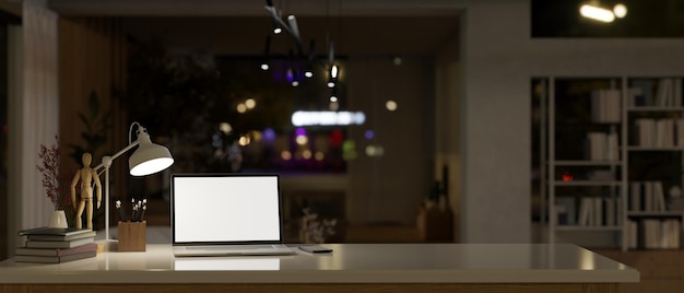 Modern office at night with laptop mockup on a tabletop