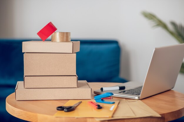 Modern office room with a laptop and various packing materials