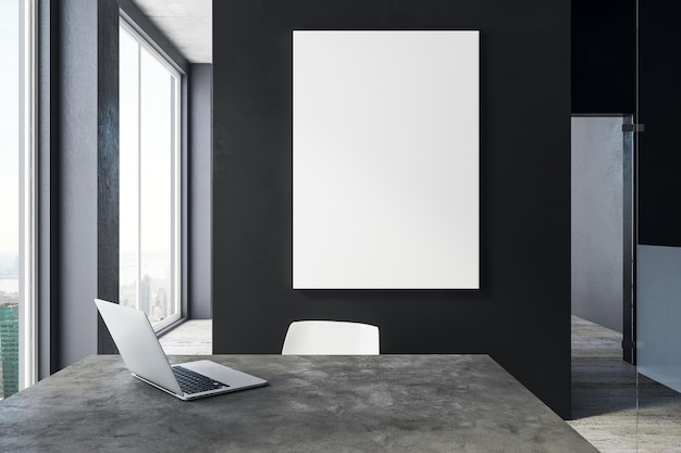 Modern office with laptop and poster