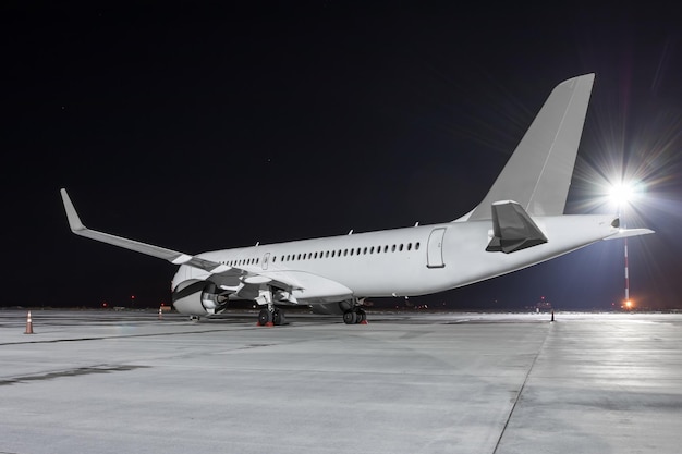 Modern passagiersvliegtuig op het schort van de nachtluchthaven