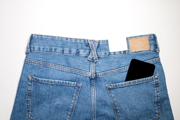 Современный телефон в заднем кармане джинсов с приложением на черном экране.