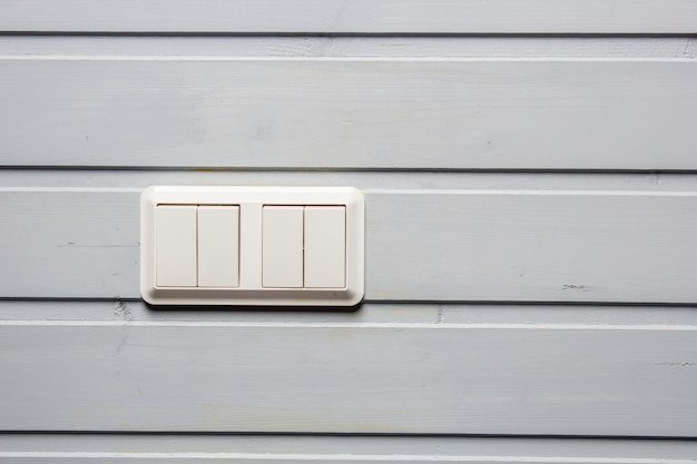 Modern plastic buttons breaker electricity of white close-up on a gray wall