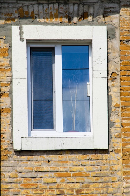 Modern plastic window on old brick wall