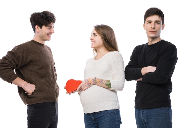 Modern polygamous family with one wife and two husbands. Young pregnant woman posing with two young man on a white background