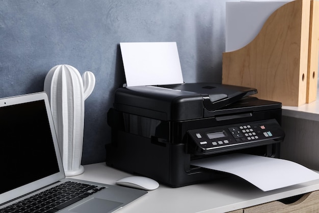 Modern printer laptop and decor element on white table