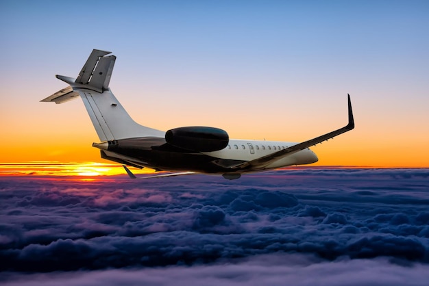 Modern private jet flying in the sunrise sky