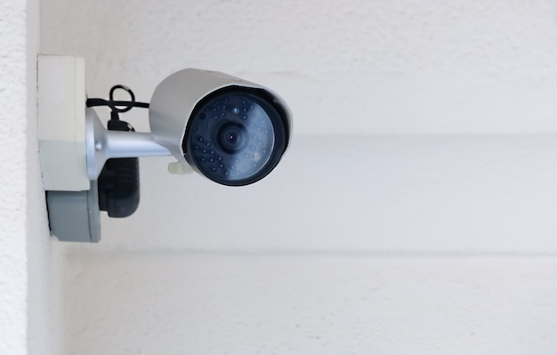 Photo modern public cctv camera on cement wall inside the building with copy space