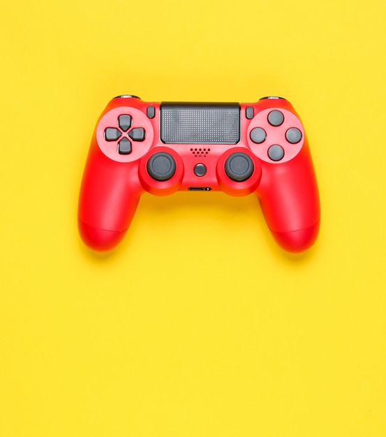 Modern red gamepad on a yellow background.