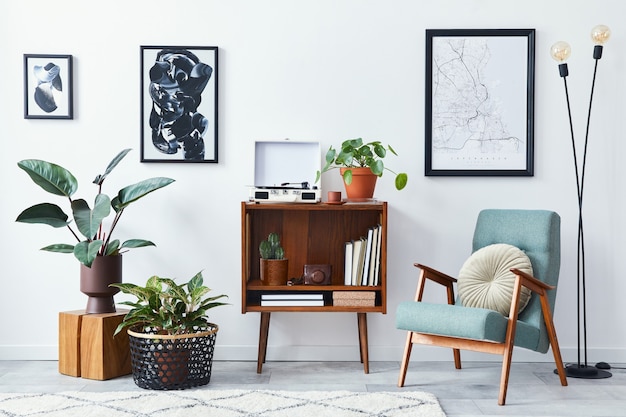 Foto moderna composizione retrò degli interni del soggiorno con mobile in legno di design, poltrona elegante, mappa poster, piante, registratore in vinile, libri e accessori personali nell'arredamento della casa.