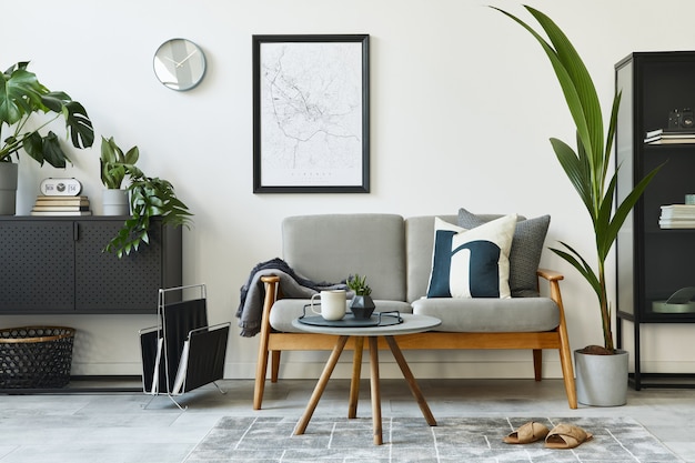 사진 디자인 회색 소파, 커피 테이블, 식물, 가구, 포스터지도, 장식 및 개인 accessoreis와 홈 인테리어의 현대 복고풍 개념. 거실의 세련된 가정 장식.