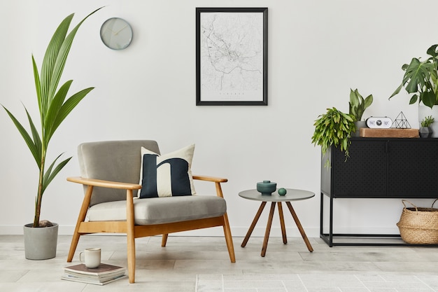 Modern retro interieurconcept met grijze design fauteuil, salontafel, planten, posterkaart, tapijt en persoonlijke accessoreis. Stijlvol huisdecor van woonkamer.