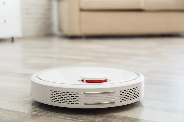 Modern robotic vacuum cleaner on floor in living room Space for text