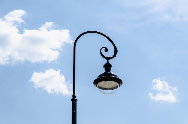 Modern round LED street lamp against a clear blue sky lamppost lantern