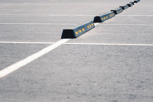 Современный резиновый барьер для автомобилей на летней парковке.