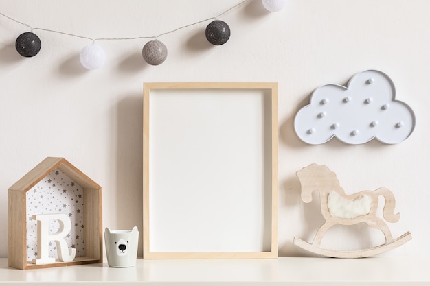 The modern scandinavian newborn baby room with photo frame, wooden car, plush toys and clouds