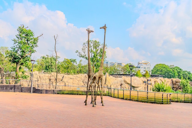 Modern sculpture of two giraffes at the zoo Two giraffe sculpture with black spots stands under a red canopy in an urban setting Kharkiv Ukraine 07072023