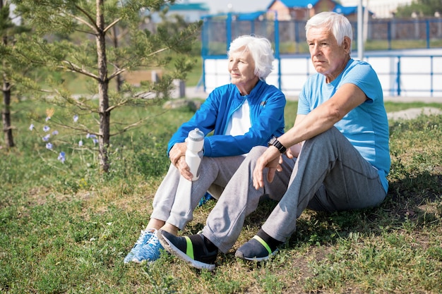 Modern Senior Couple Resting on Lawn