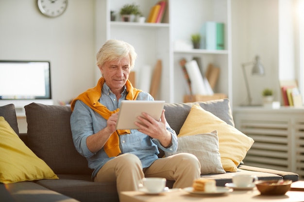 Modern Senior Man Using Tablet at Home