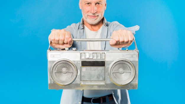 Modern senior man with vintage radio