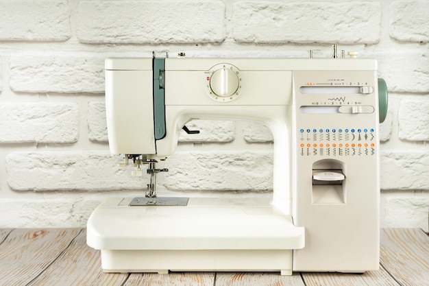 Modern sewing machine on table in tailor's workshop