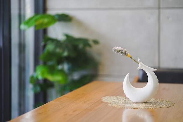 Modern shaped flower vases white decorate the wooden table in the room.