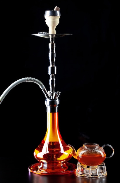 Modern shisha and glass teapot on black close up