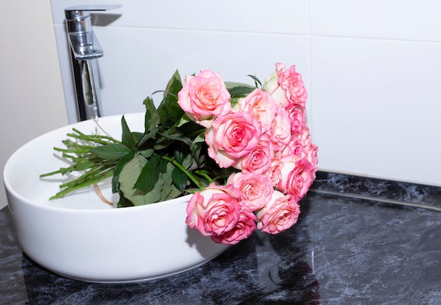 Modern sink with beautiful roses in kitchen