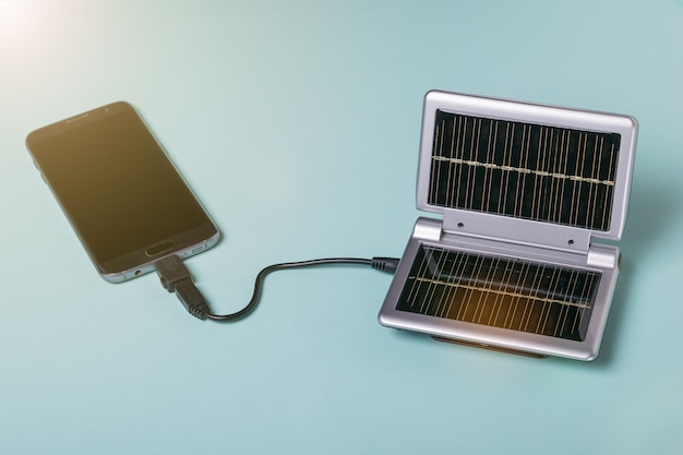 A modern smartphone is charged from the energy of the sun