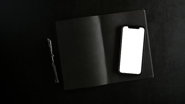 Modern smartphone in white blank screen mockup on black background top view overhead flat lay