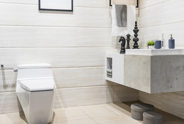 Modern spacious bathroom with bright tiles with glass shower, toilet and sink. 