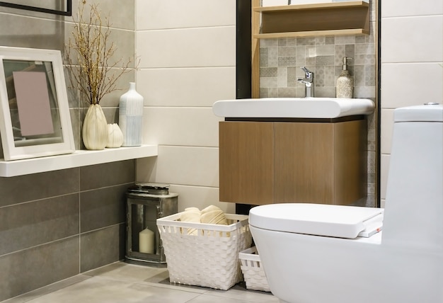 Modern spacious bathroom with bright tiles with toilet and sink. Side view