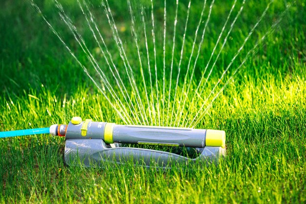 Modern sprinkler working on grass irrigation multiple sprinkler system watering the fresh lawn